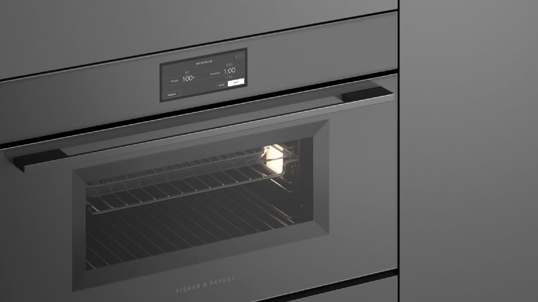 Close up of a dark grey oven with a lit interior