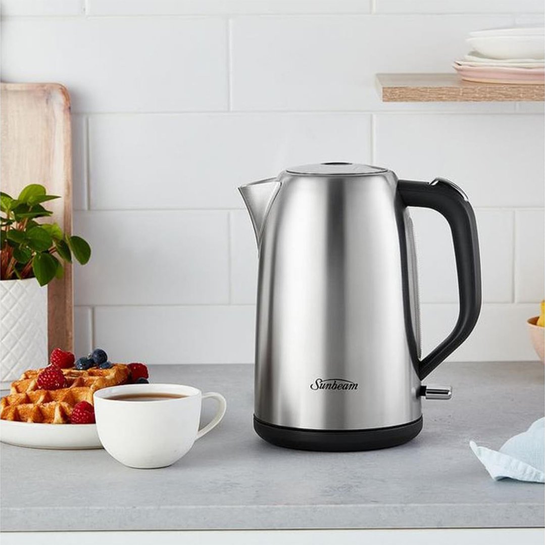 Sunbeam kettle on a kitchen counter with waffles and a cup of tea