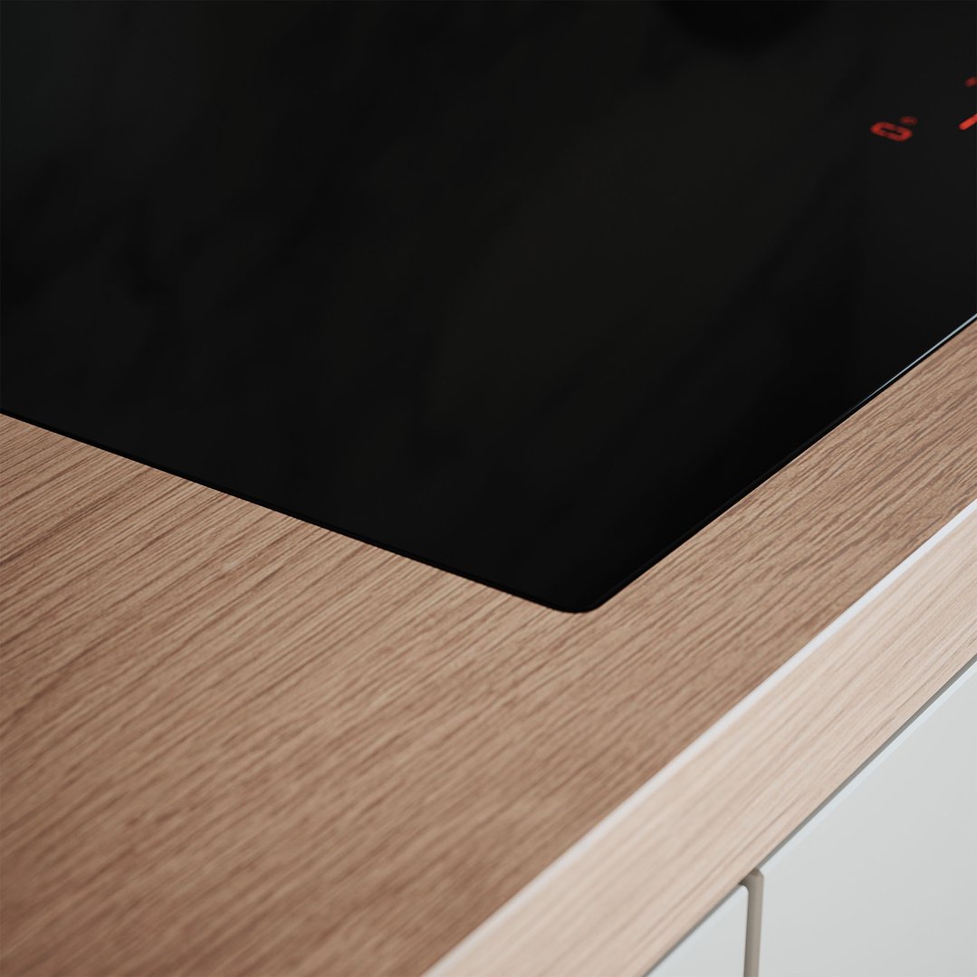 Close up of a black induction cooktop built into a light wood countertop