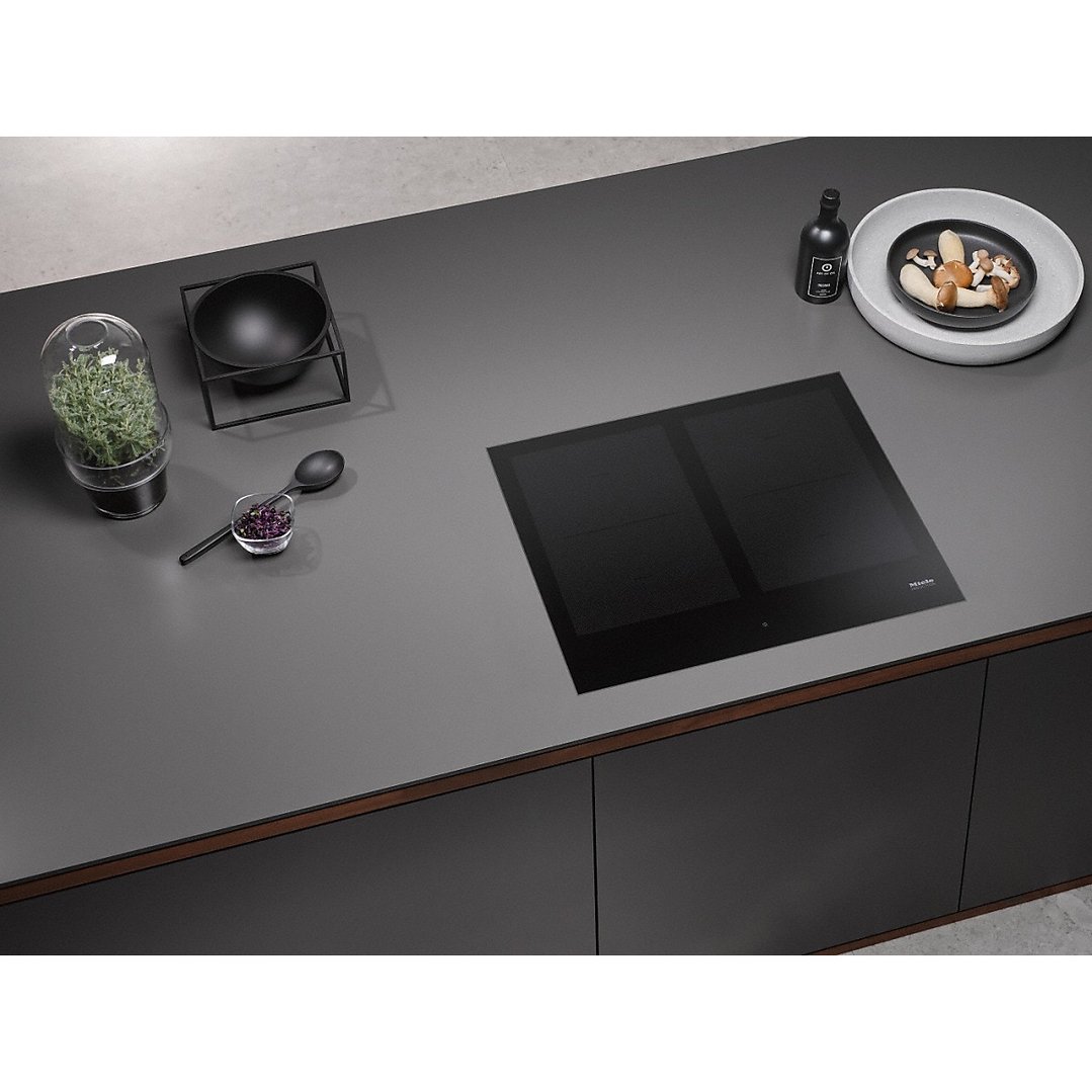 Induction cooktop in a modern kitchen with various cooking accessories