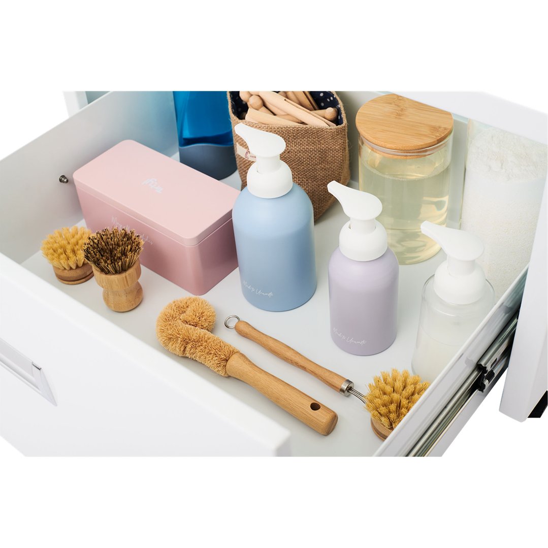 Drawer of a laundry pedestal filled with cleaning supplies and brushes