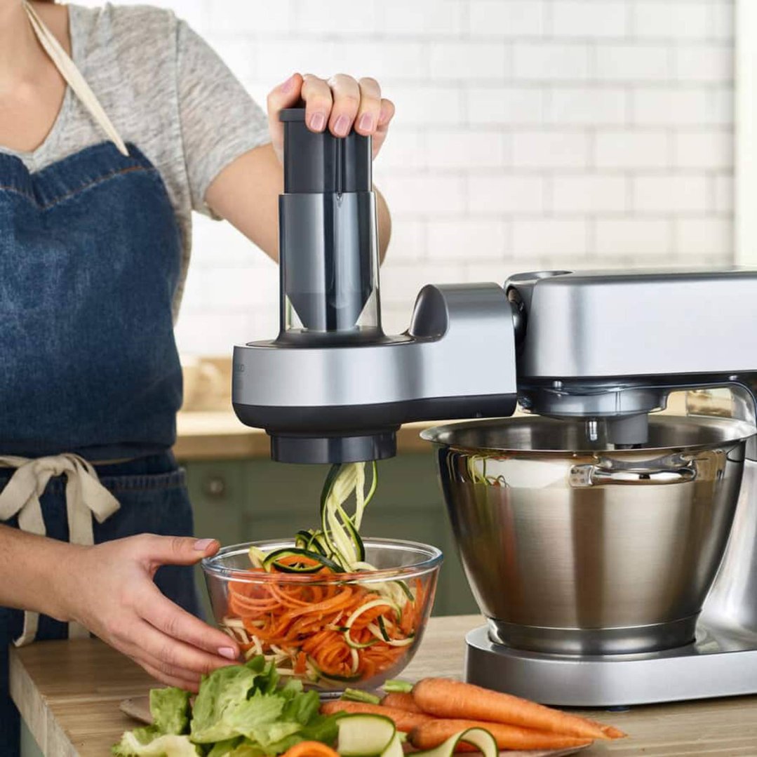Woman using a spiralizer attachment on a stand mixer to make vegetable noodles