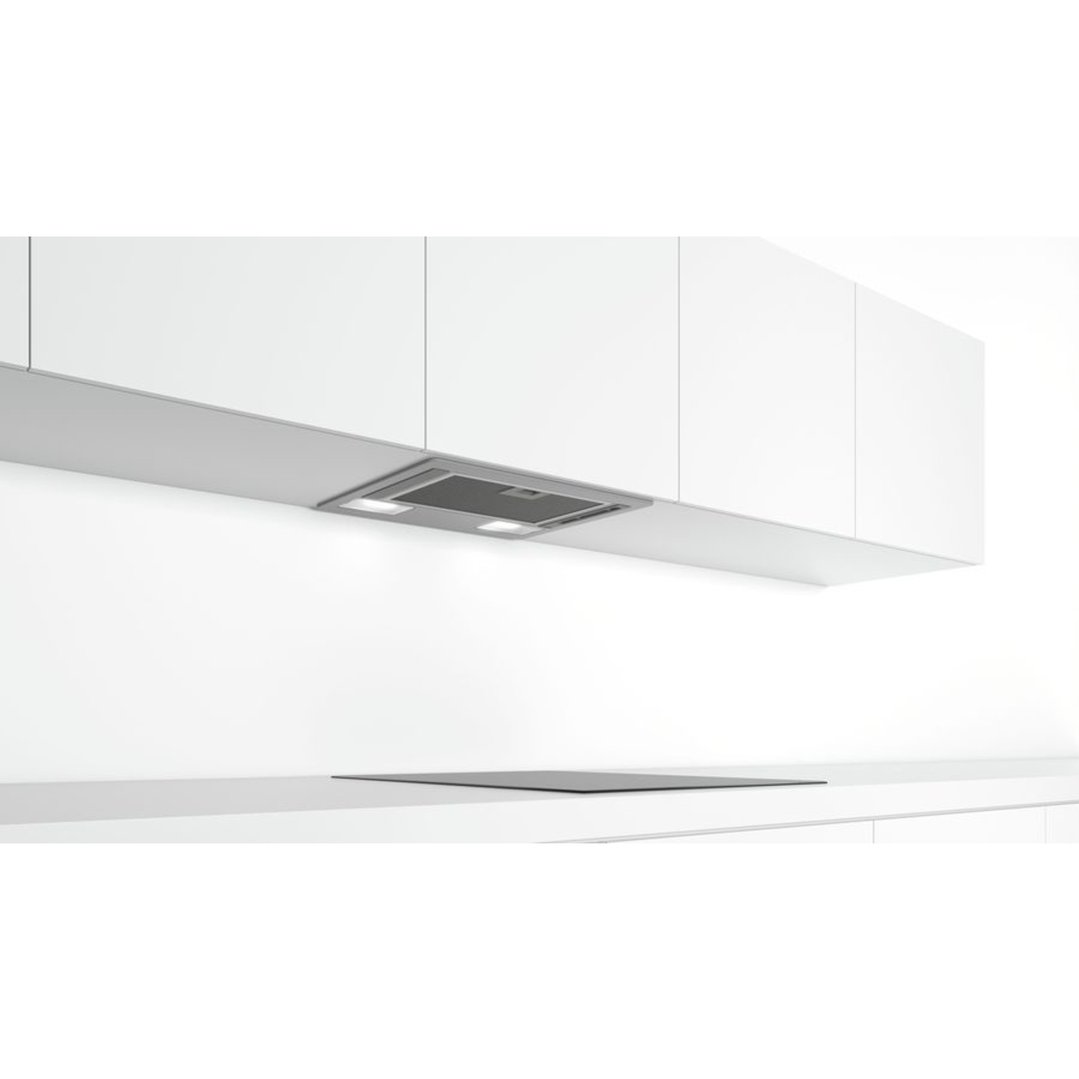 Integrated rangehood with lights above a cooktop in a modern kitchen