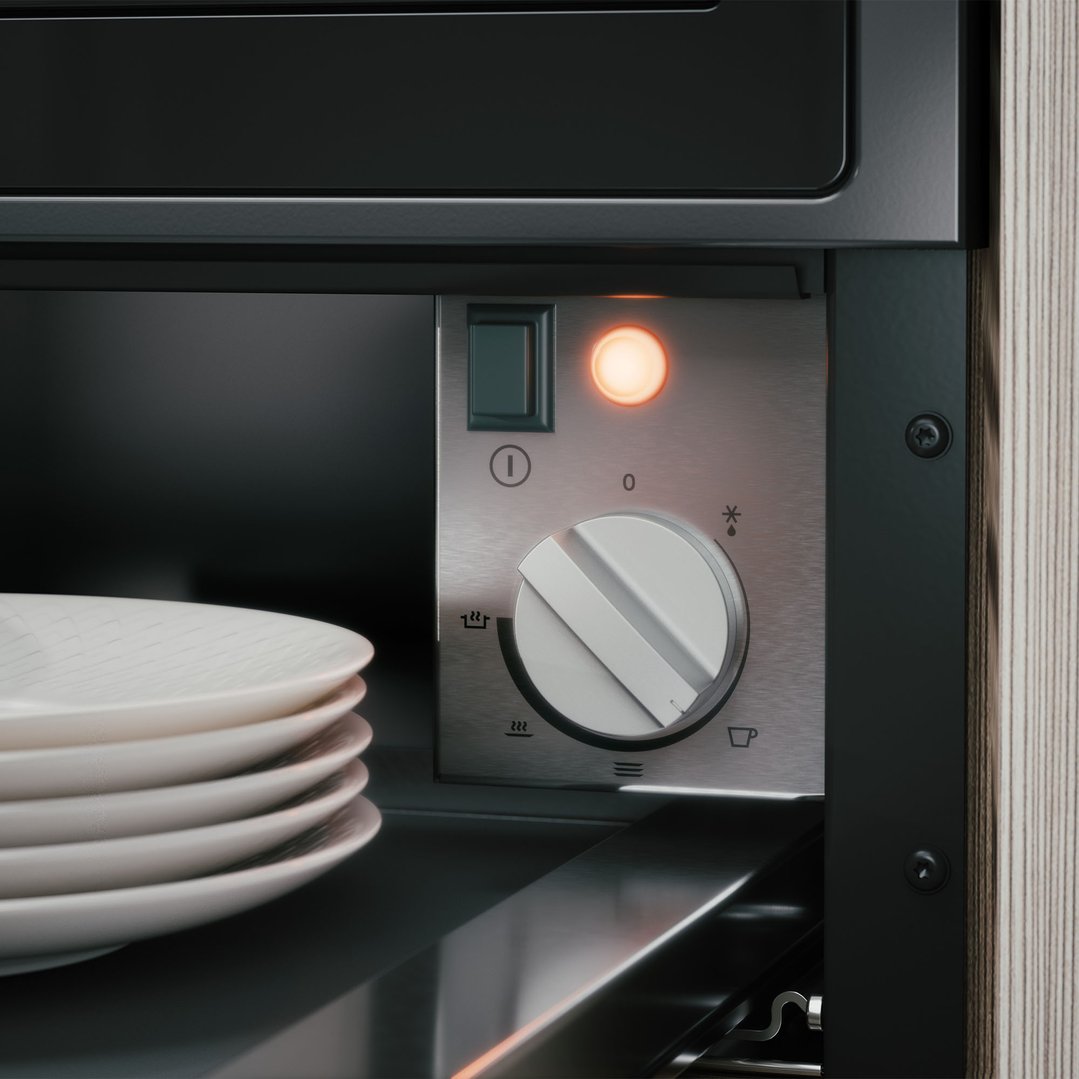 Close up of a warming drawer with stacked plates inside