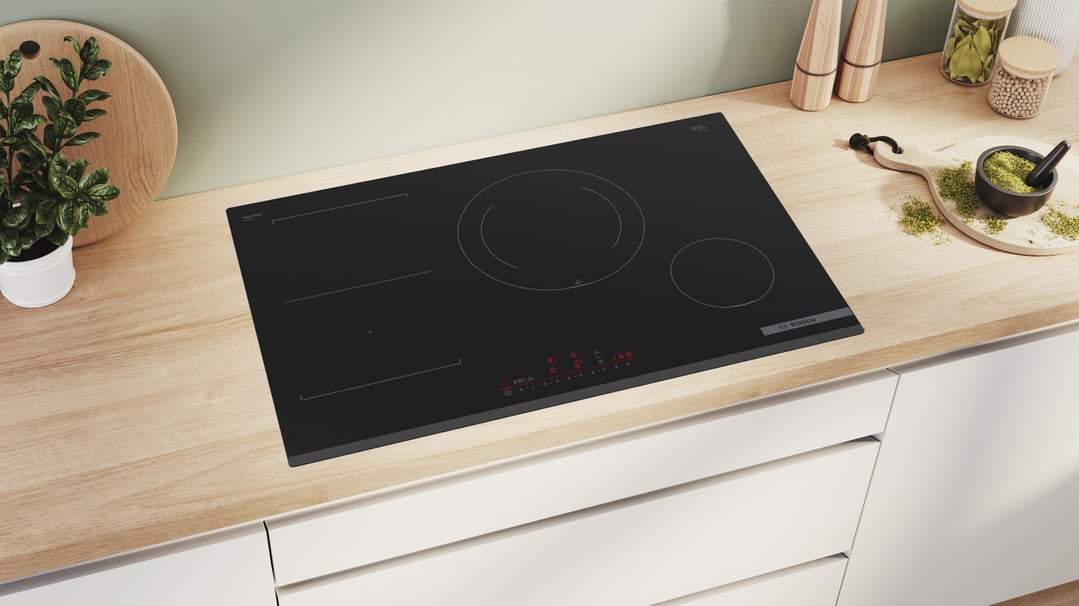 Black Bosch induction cooktop built into a light wood kitchen countertop