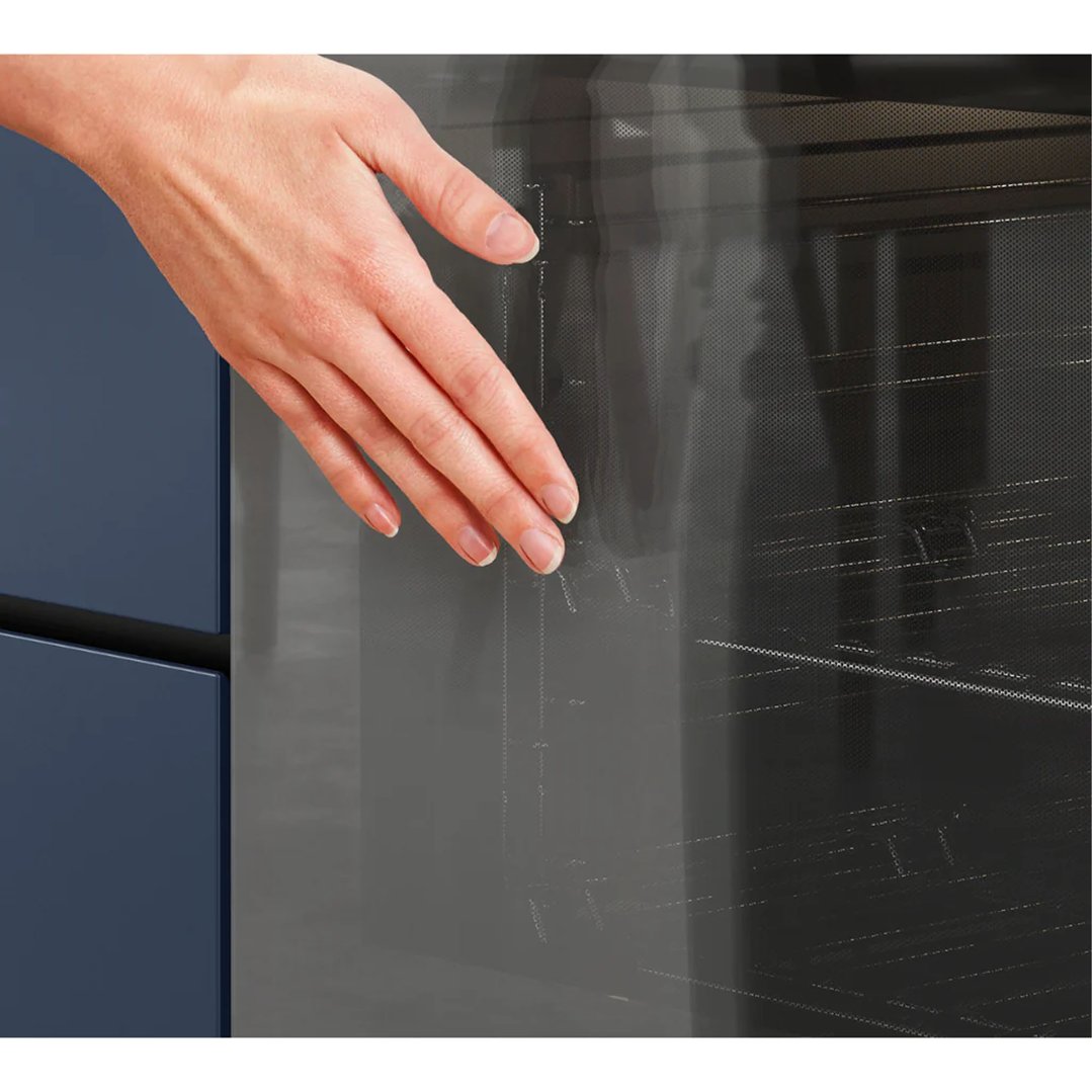 A hand reaching into the open door of a Westinghouse oven