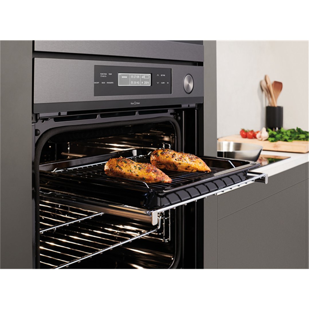 Two seasoned chicken breasts cooking on a rack in a built-in oven