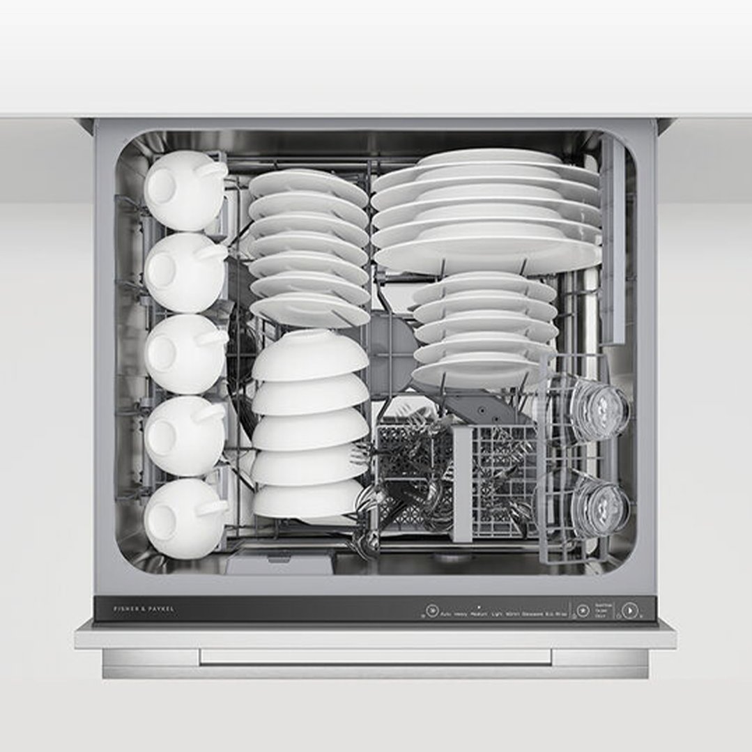 A DishDrawer dishwasher with white dishes and clear glasses inside