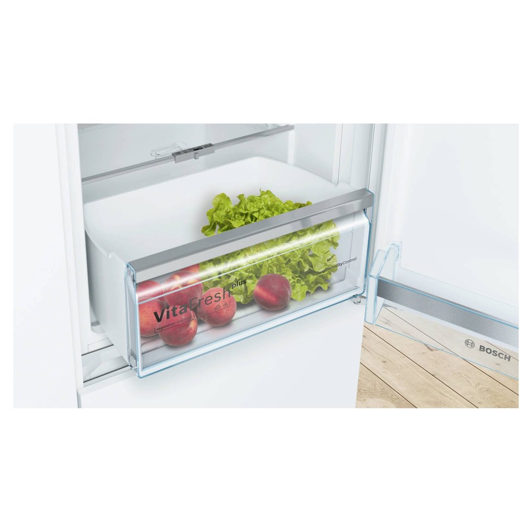 Open fridge-freezer drawer with fresh lettuce and peaches inside