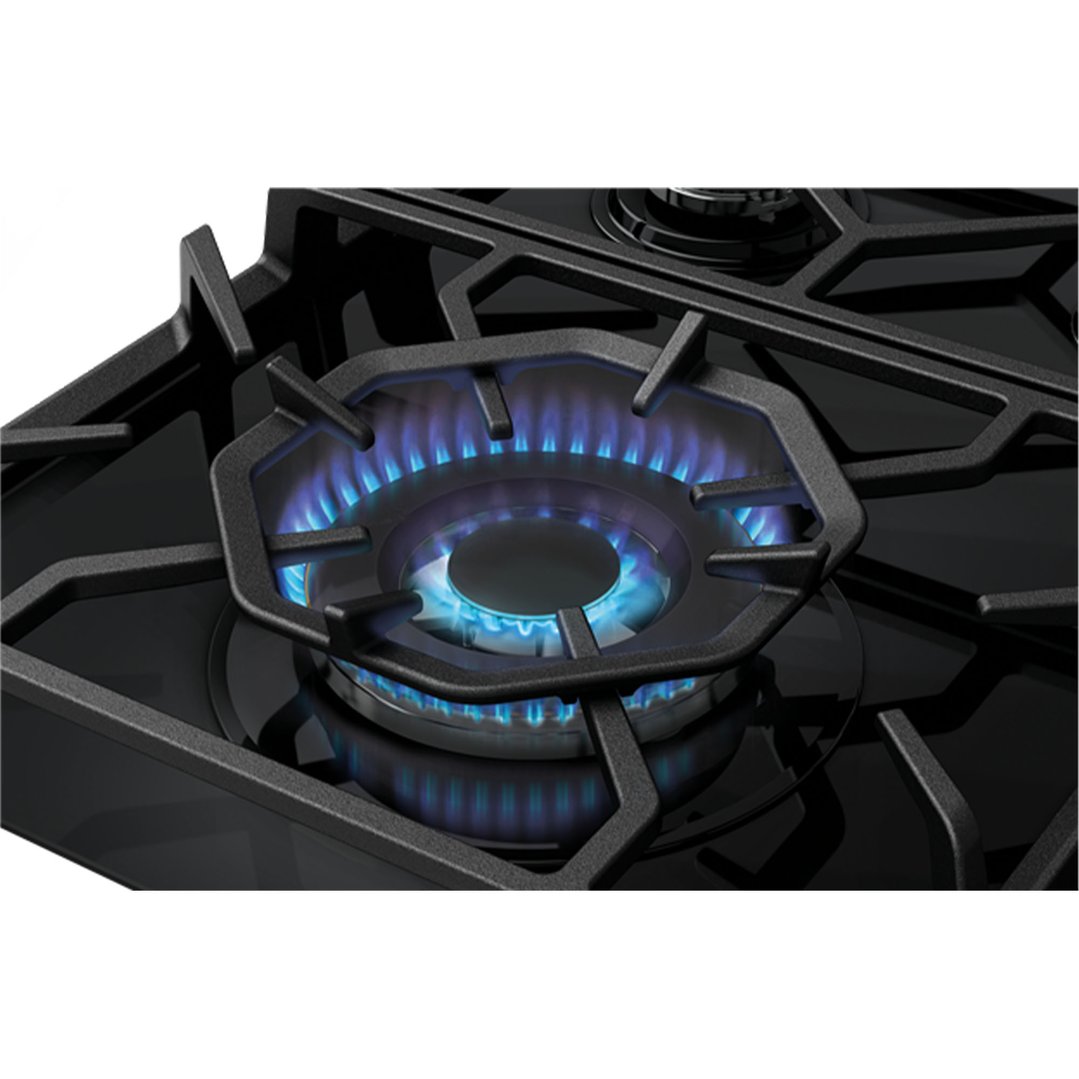 Close up of a gas cooktop burner with blue flames on a black surface