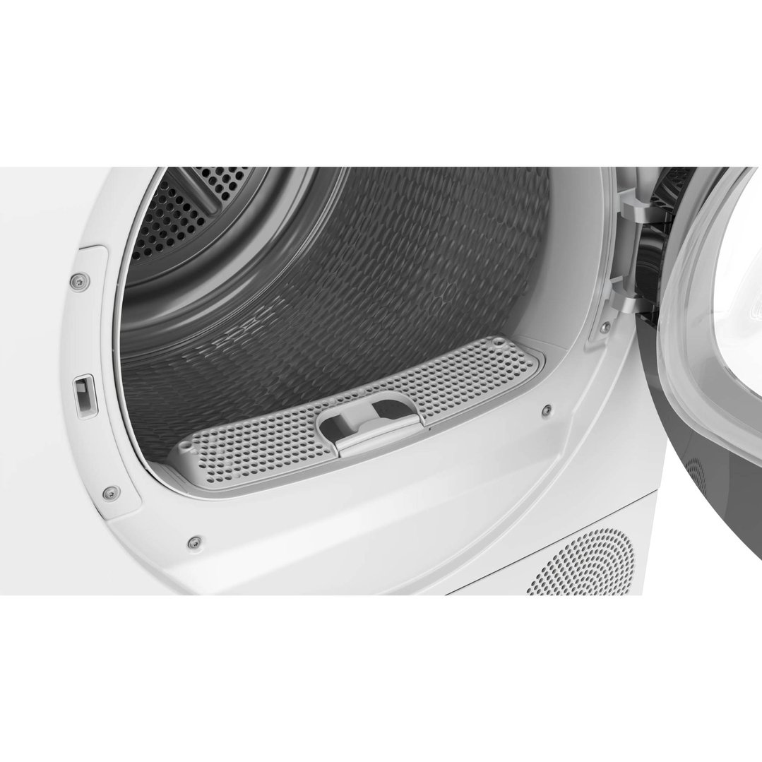 Close-up of the open drum and lint filter of a white heat pump dryer