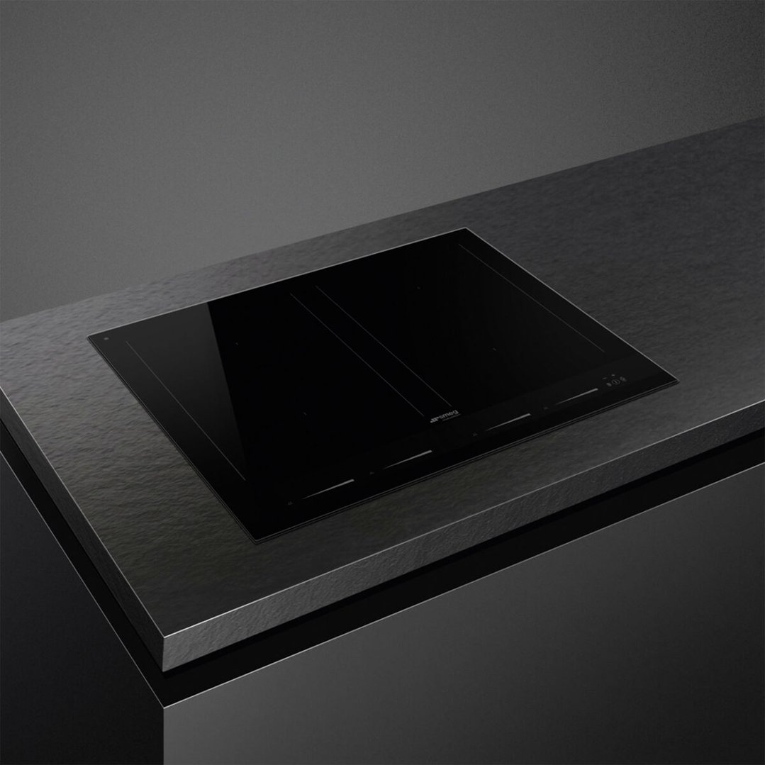 Black induction cooktop integrated into a dark textured kitchen countertop