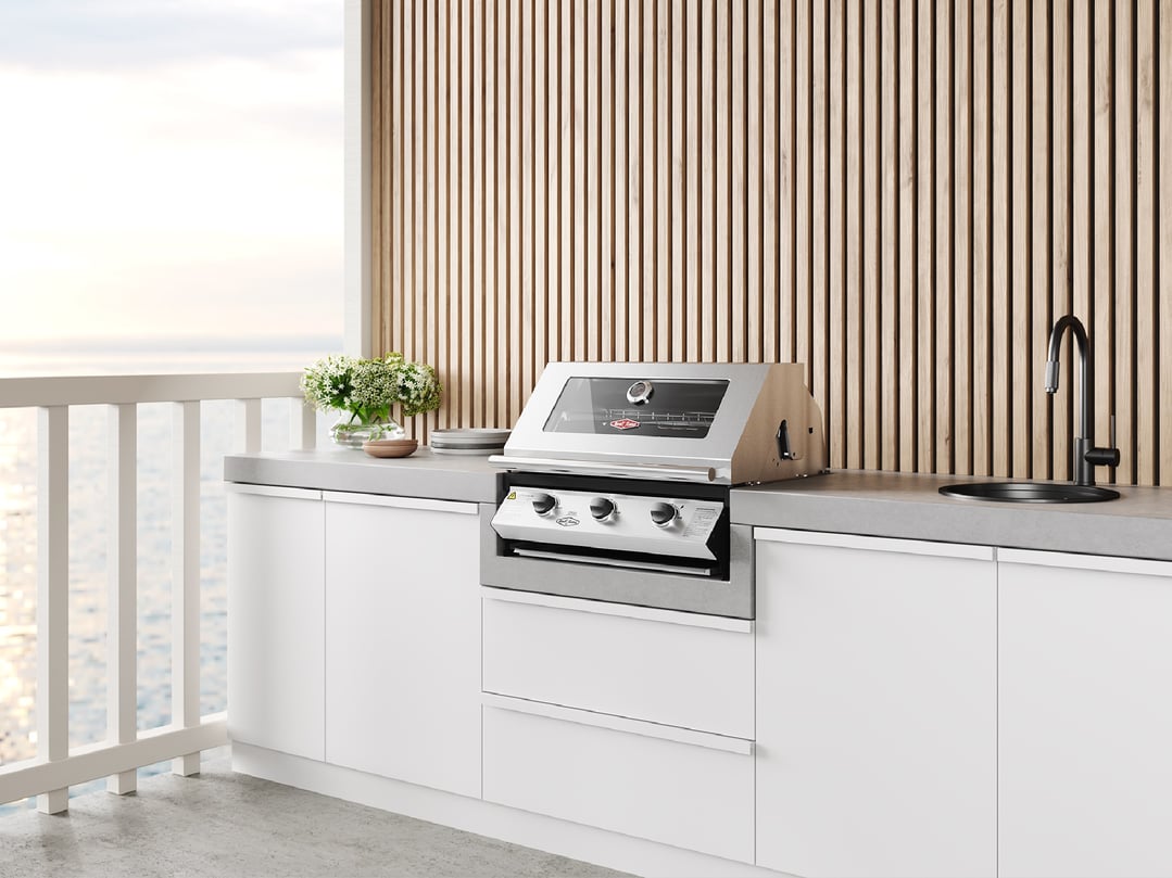 Built-in barbecue on an outdoor kitchen counter with a view of the ocean