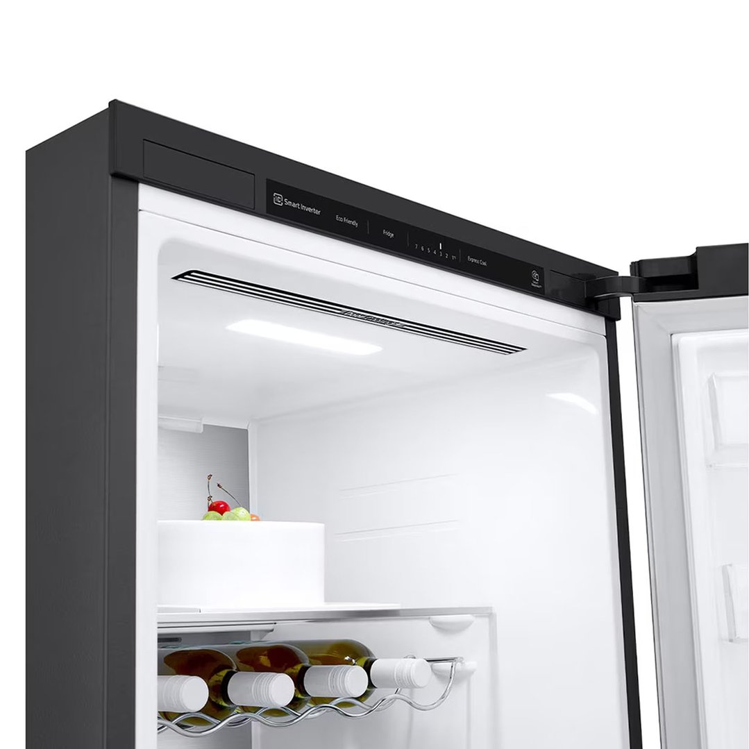 Open single door fridge interior with food, wine bottles, and control panel