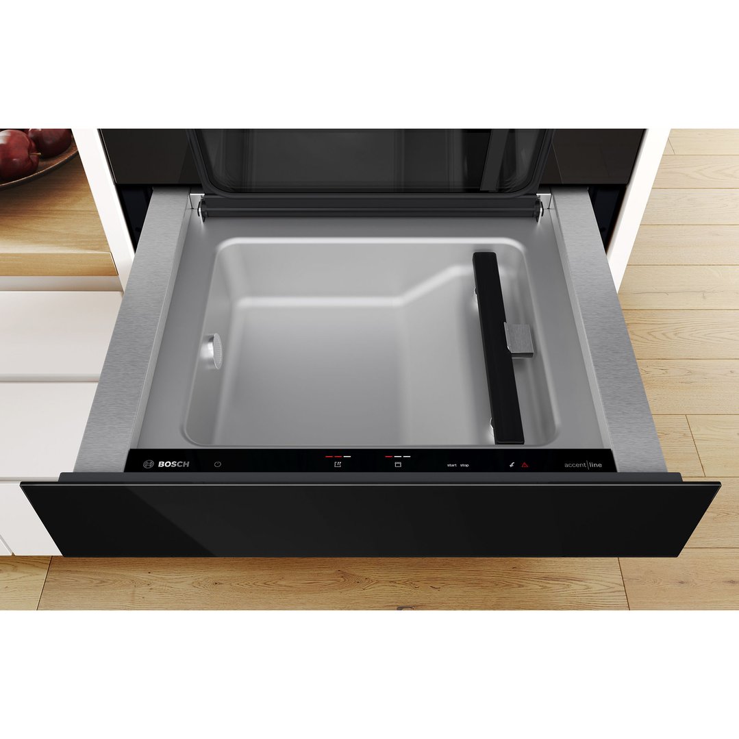 Open vacuum drawer with controls visible, built into a kitchen cabinet