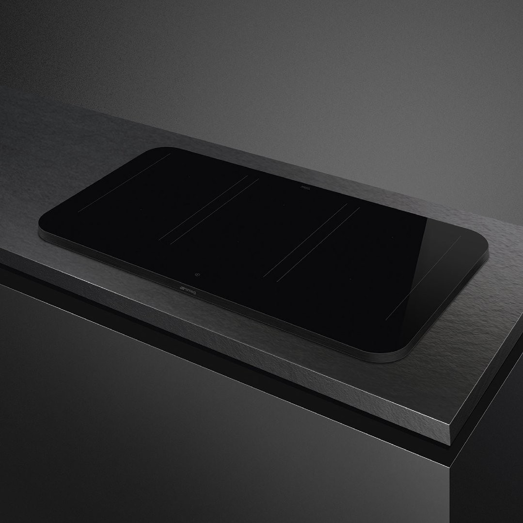 Matte black induction cooktop with two cooking zones on a dark countertop