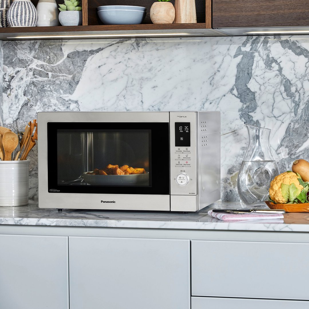 Panasonic microwave oven on a marble countertop with food inside