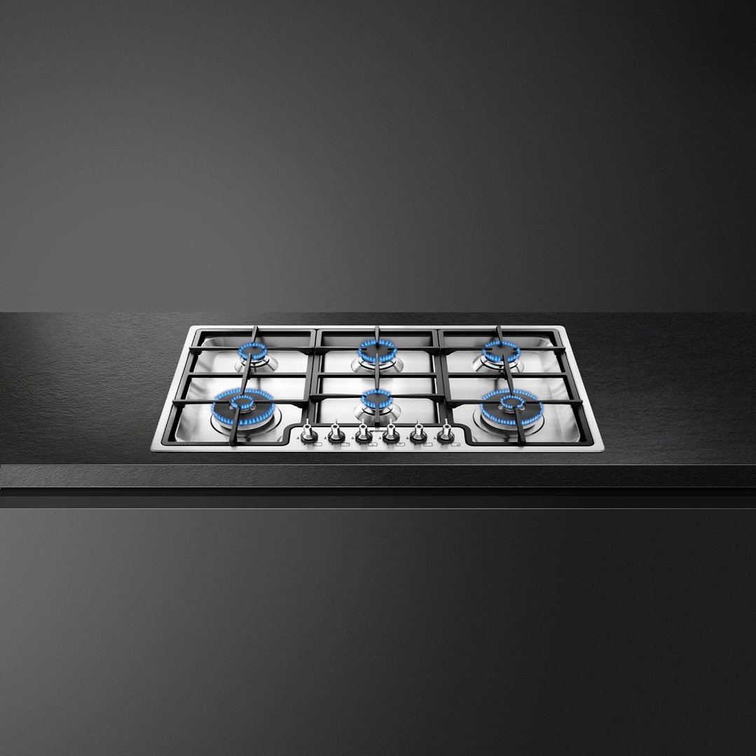 SMEG 90cm 6 burner gas cooktop with blue flames on a dark countertop