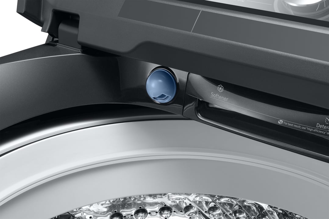 Close-up of the softener dispenser and top-loading drum of a black washing machine