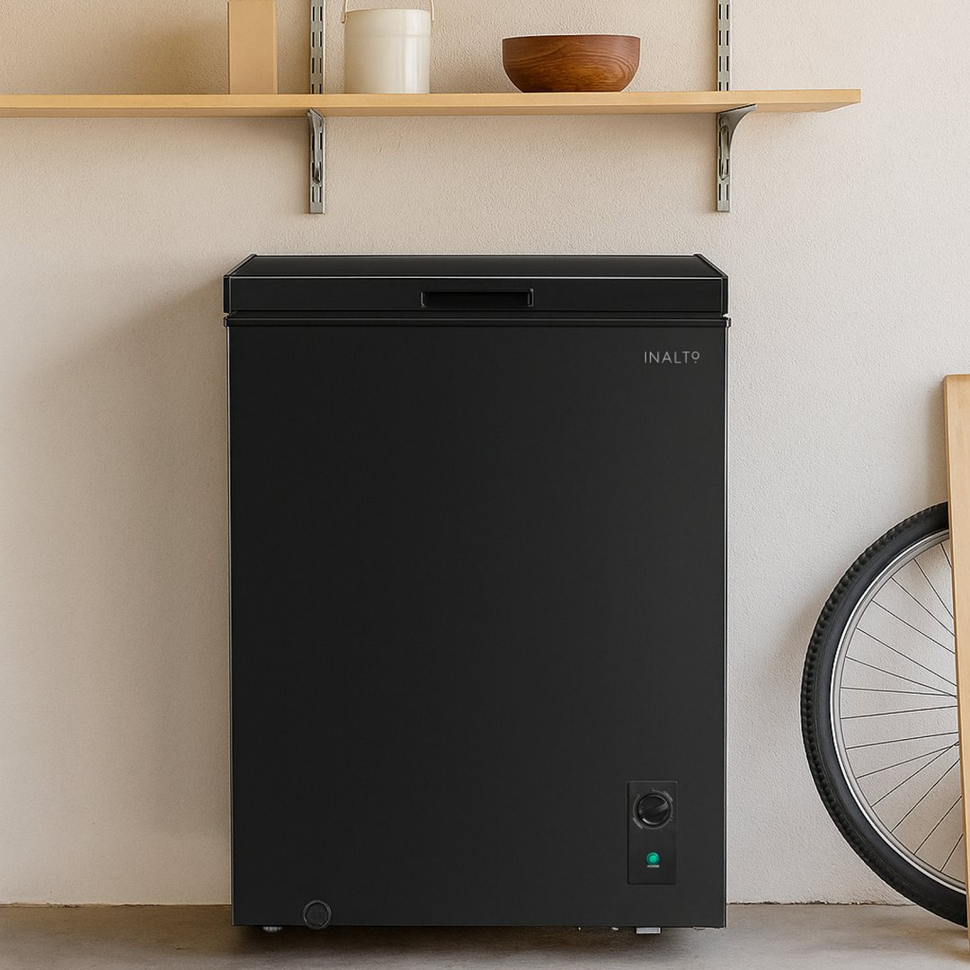 Black Inalto chest freezer in a garage with a shelf and bicycle wheel