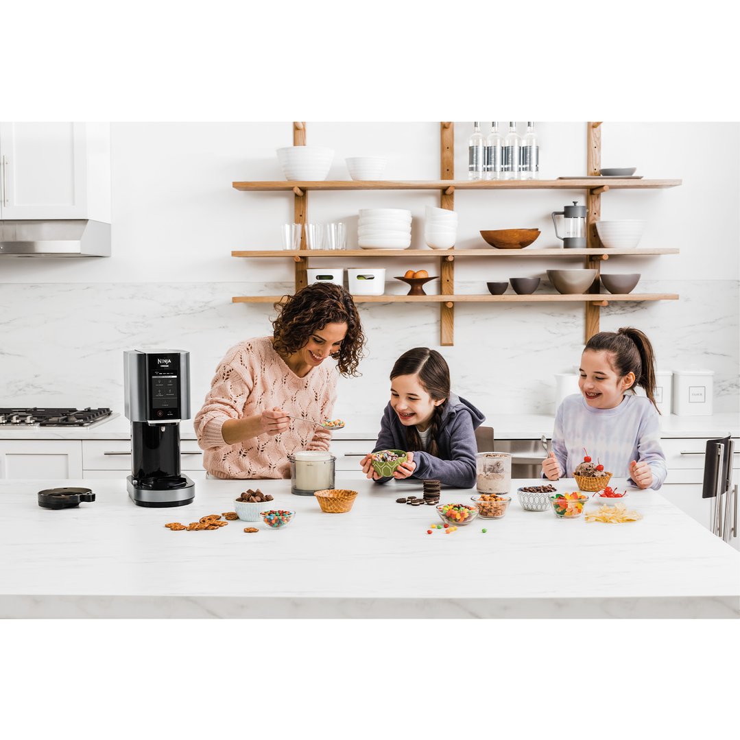 Woman and two girls making ice cream with a Ninja CREAMi ice cream maker