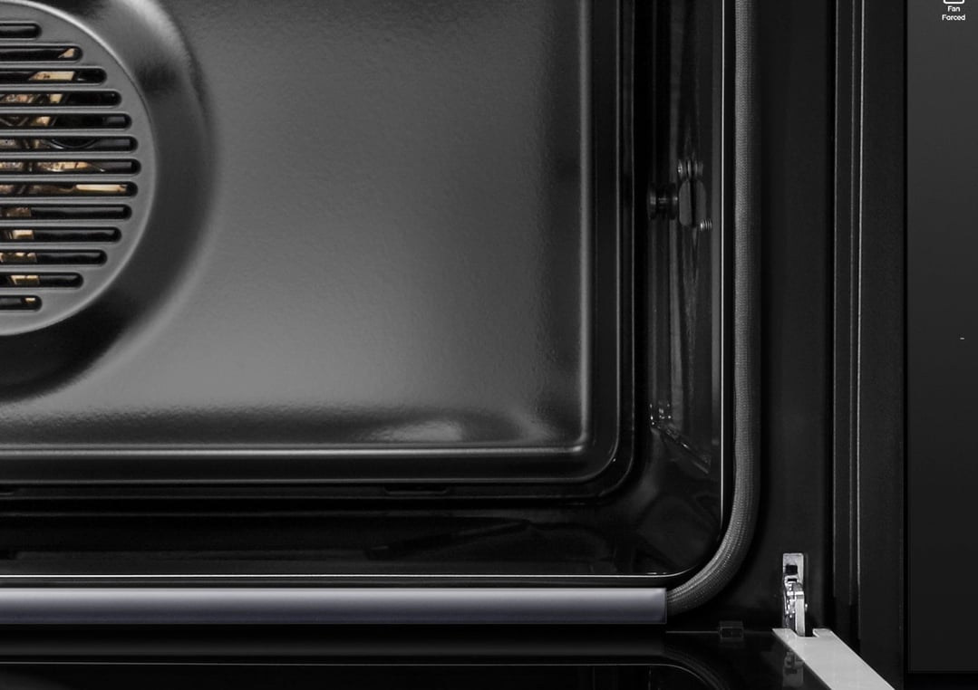 Close-up view inside a black oven with a fan on the left