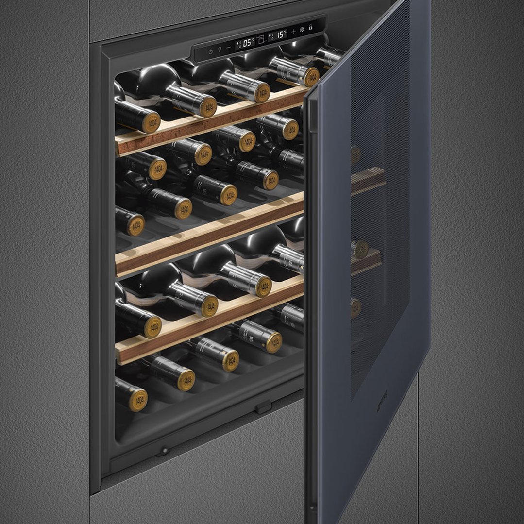 Built-in wine cellar with an open door showing bottles on wooden shelves