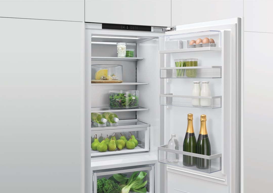 Open integrated dual zone refrigerator filled with food and drinks
