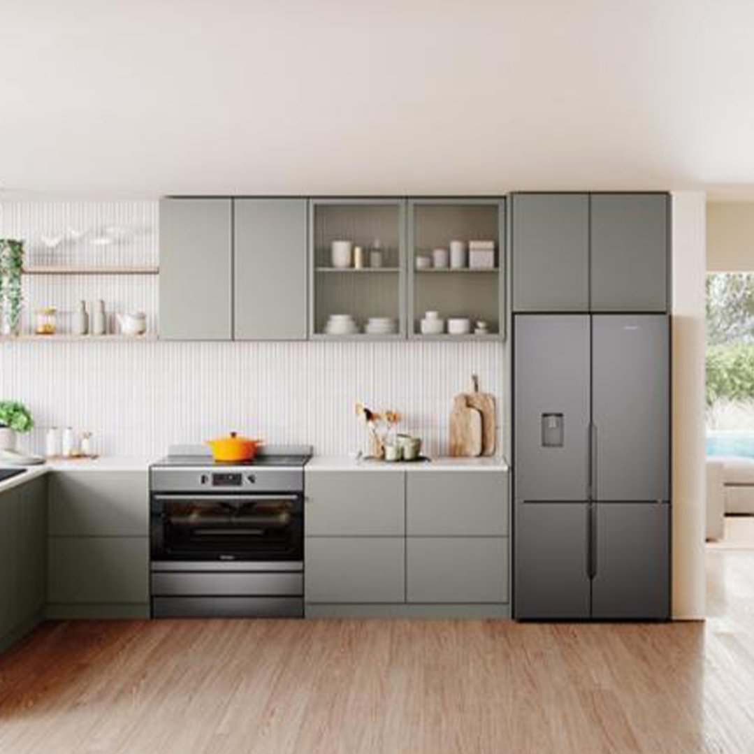 Dark stainless steel freestanding oven in a modern kitchen with light wood floor