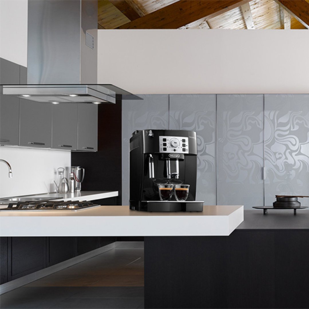 Black fully automatic coffee machine on a kitchen counter with two espresso cups