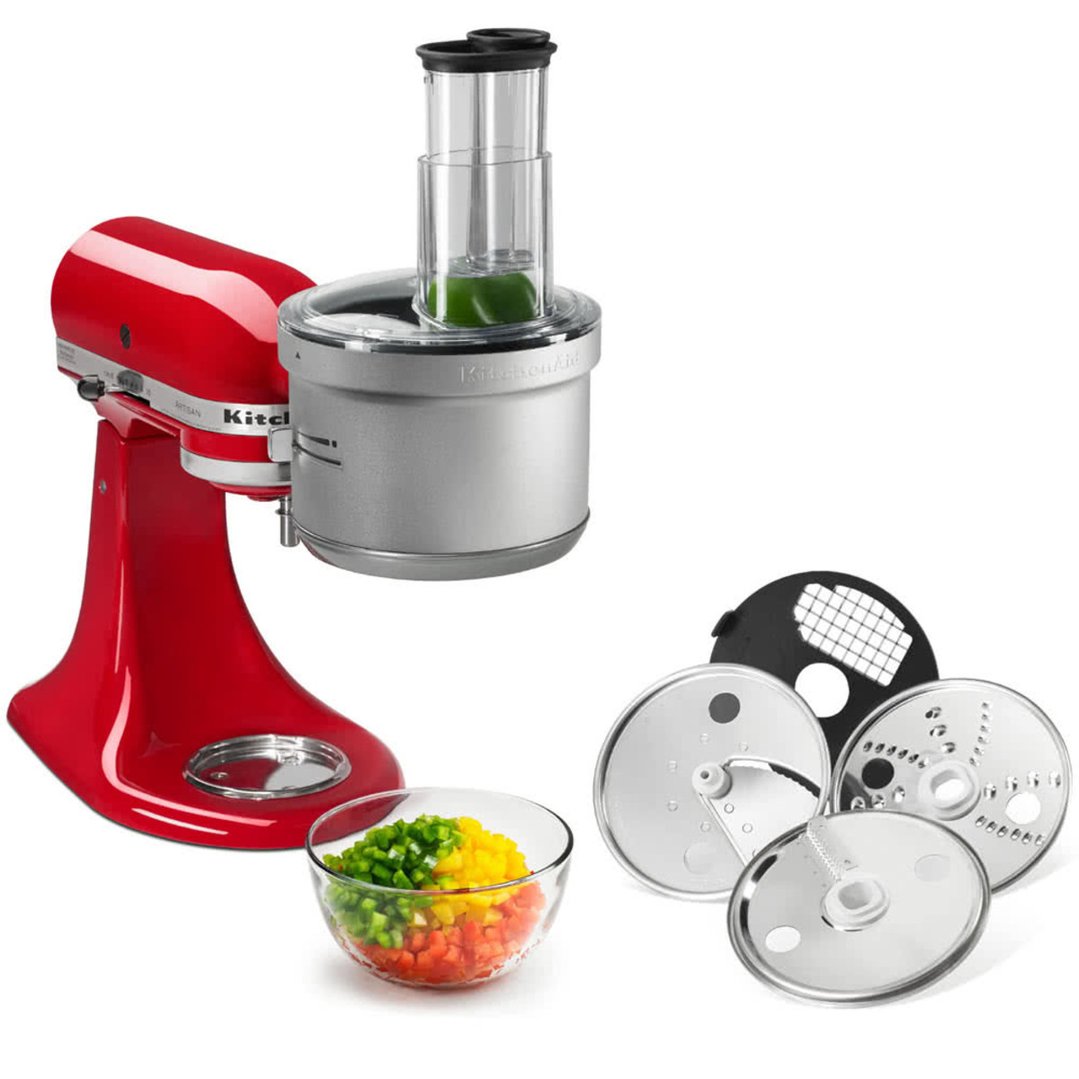 Red stand mixer with food processor attachment, bowl of chopped vegetables, and blades
