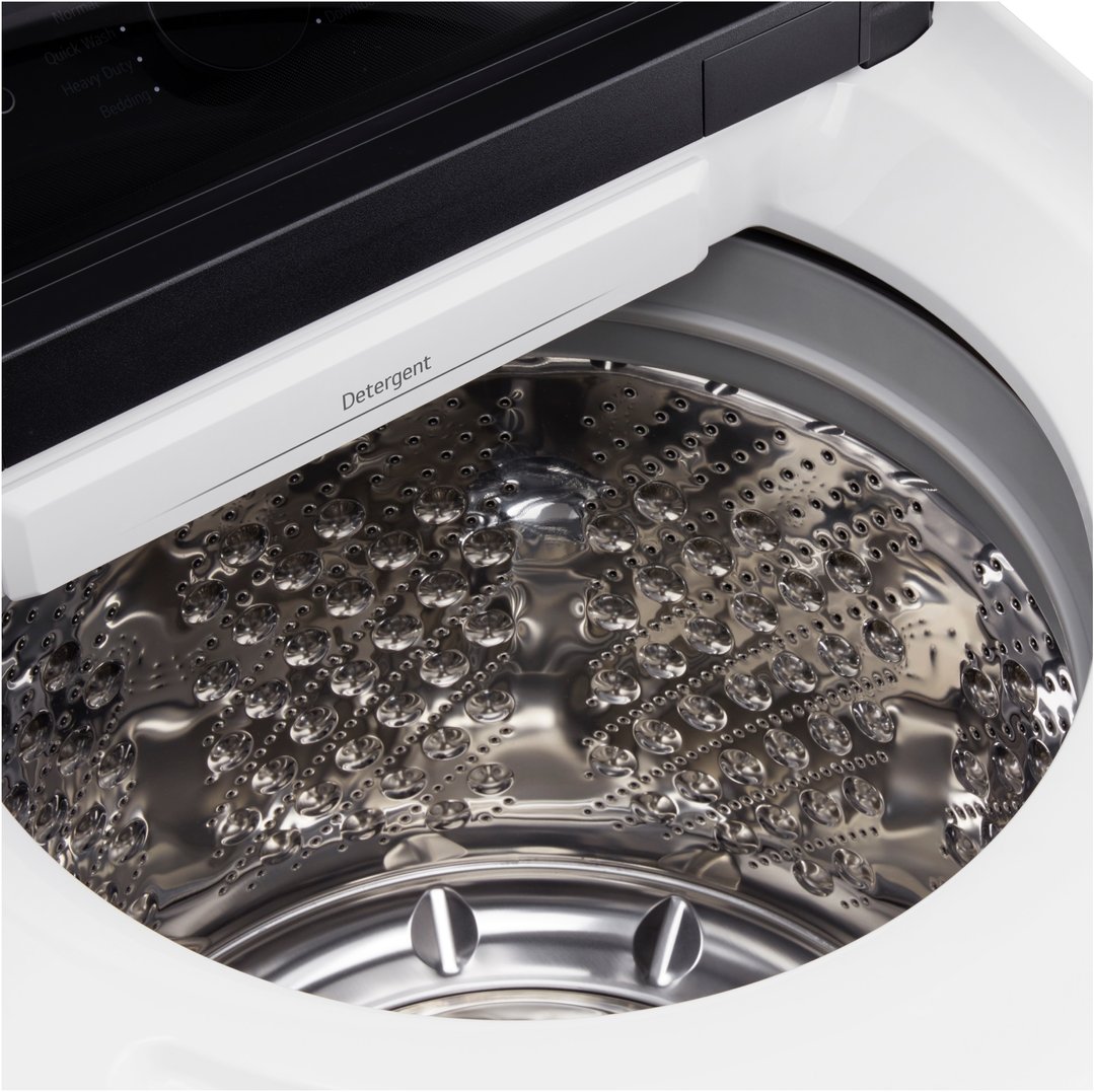 Close-up of the inside of a top load washing machine drum with detergent dispenser