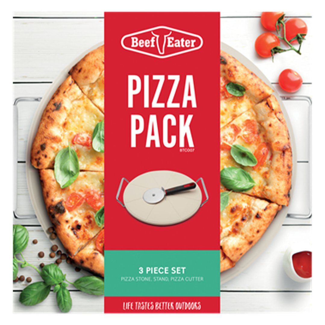 Pizza stone set packaging with a pizza and fresh ingredients on a white wooden table