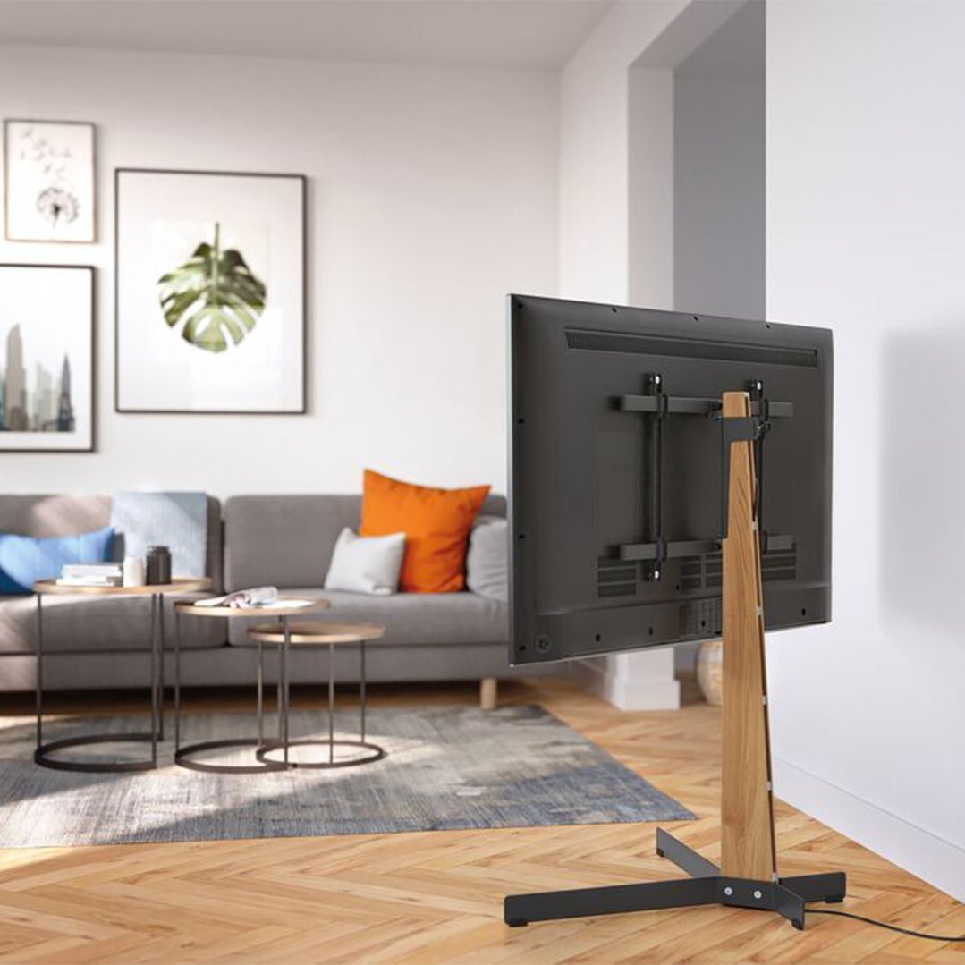 TV floor stand with a TV in a living room with a sofa and tables