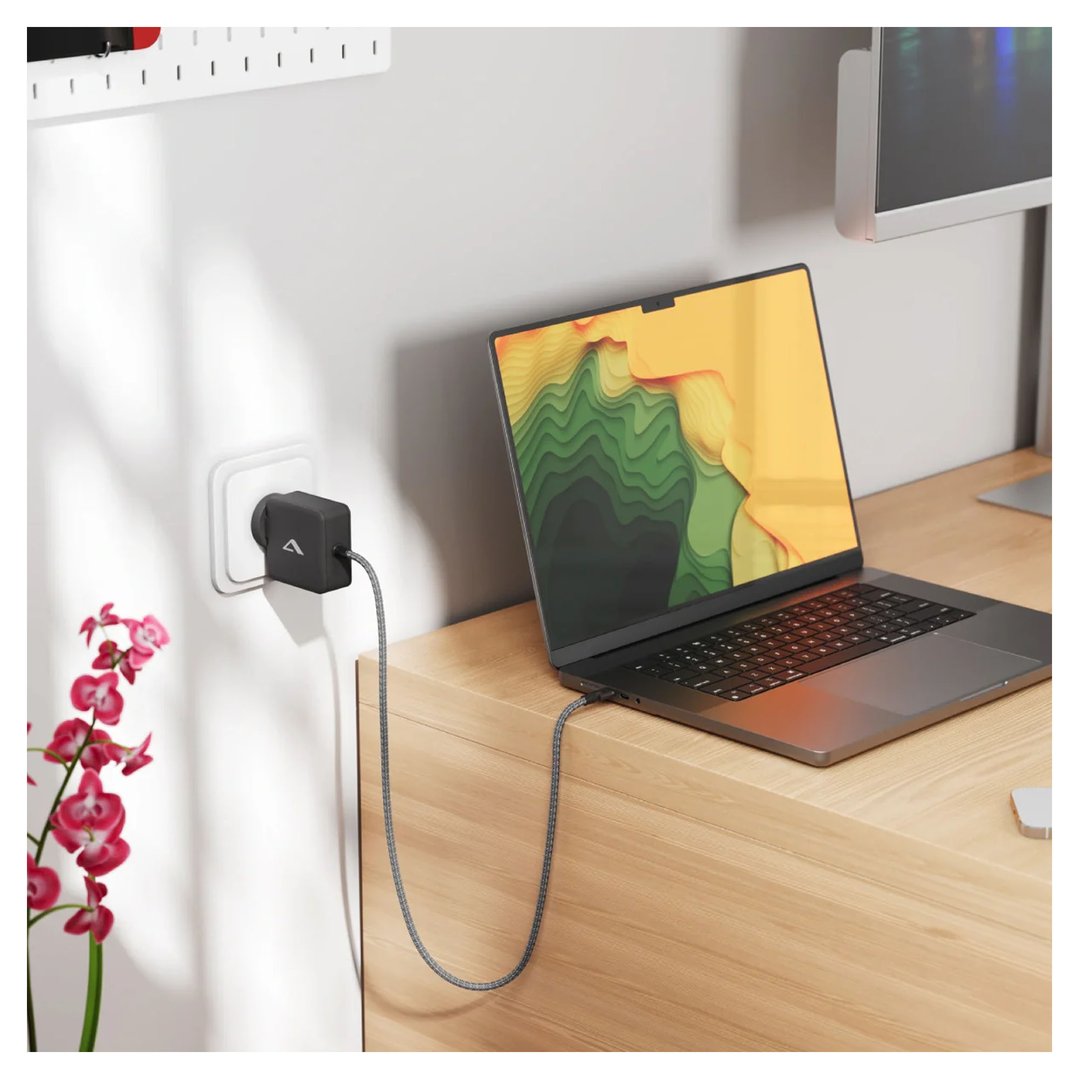 ALOGIC Rapid Power 65W GaN Charger charging a laptop on a wooden desk