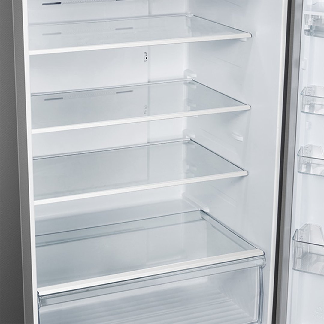 Interior view of a fridge with clear glass shelves and a bottom drawer