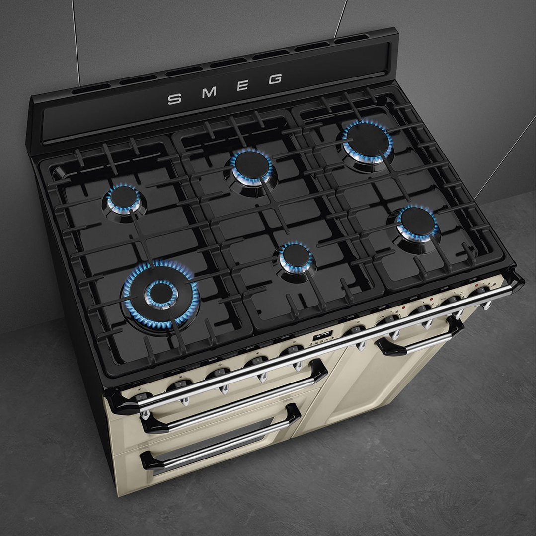 Overhead view of a cream freestanding cooker with gas burners lit