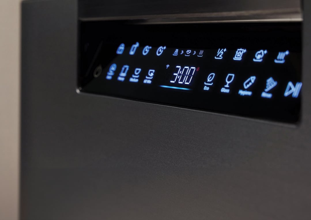 Close up of a dishwasher control panel with illuminated blue icons