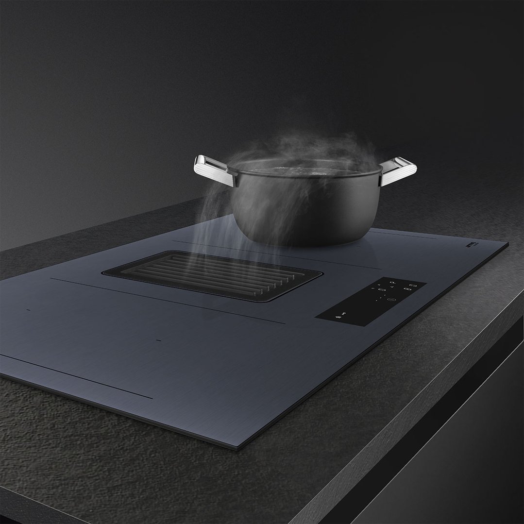 Induction cooktop with integrated ventilation system in a dark kitchen setting
