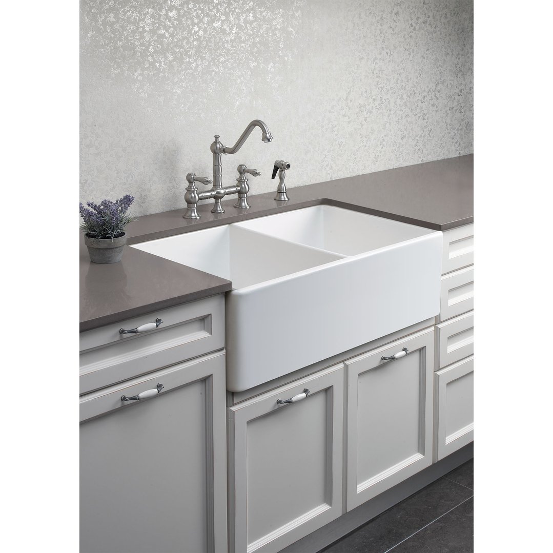 Double bowl fireclay sink with faucet in a kitchen with grey cabinets