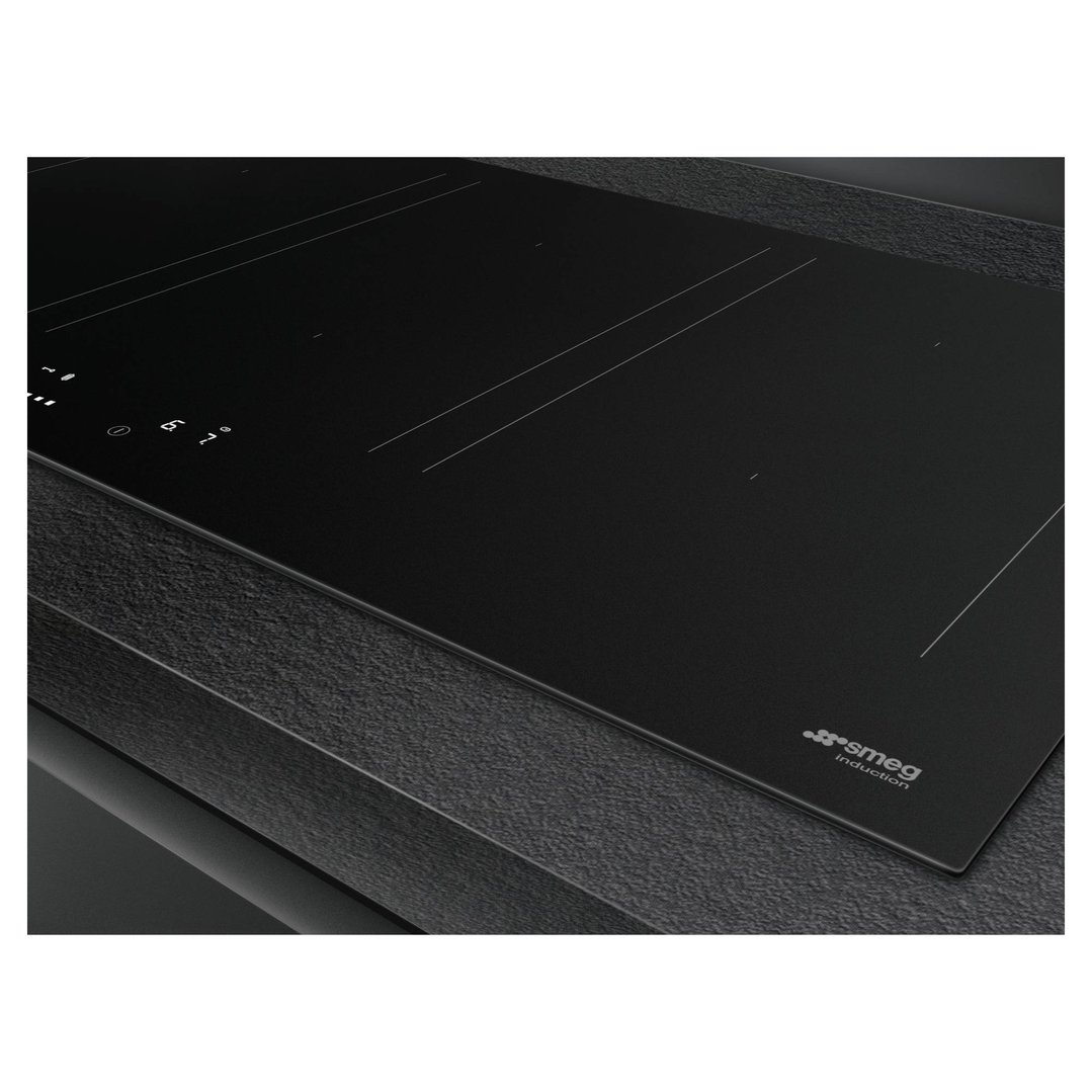 Matte black induction cooktop with controls on a dark textured countertop