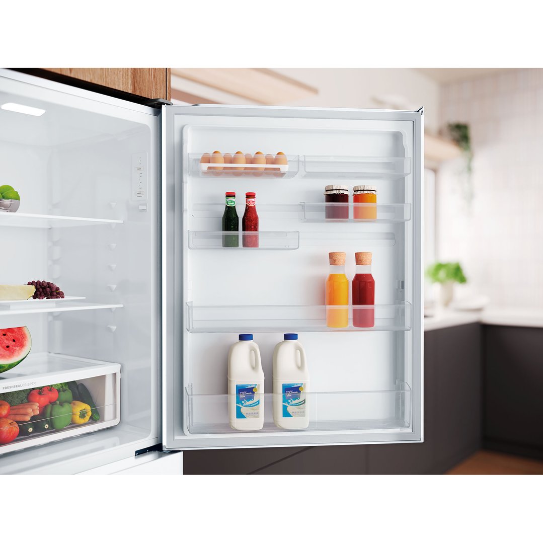 Open Westinghouse bottom mount fridge with food in a kitchen setting