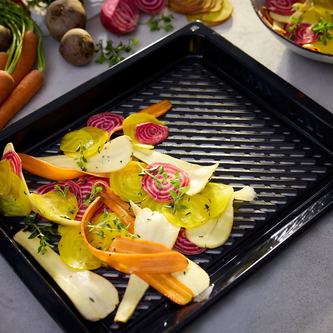Air Fry & Grill tray with sliced vegetables and herbs on a counter