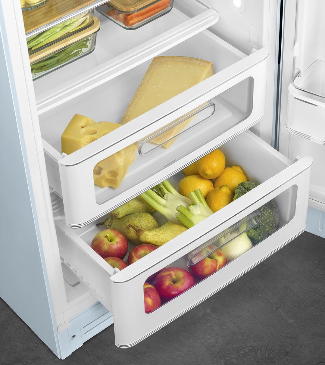 Open refrigerator drawers filled with cheese, lemons, pears, apples, and vegetables