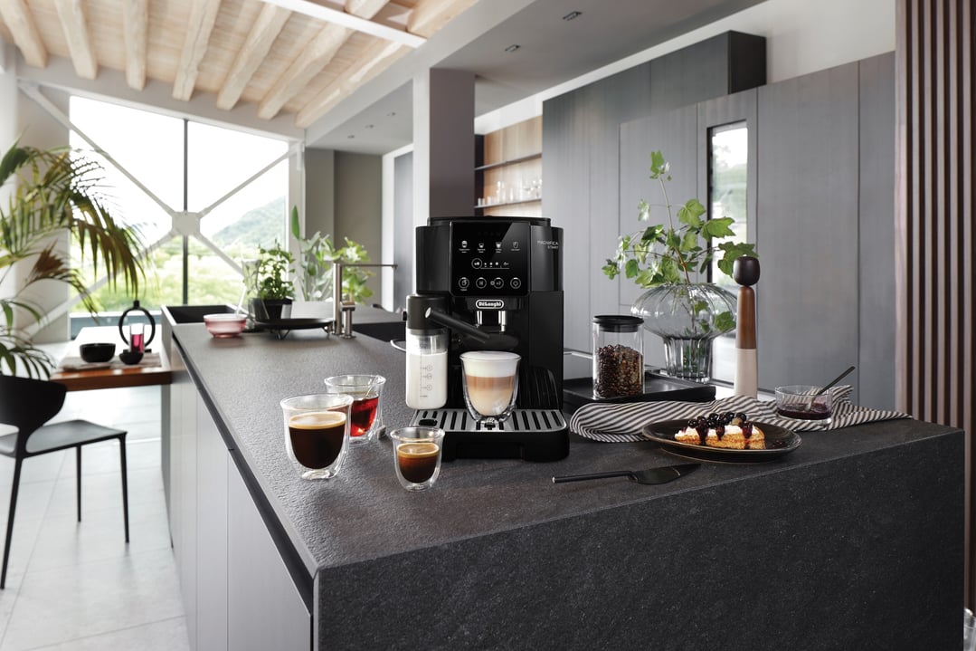 Magnifica Start coffee machine on a kitchen island with coffee and pastries