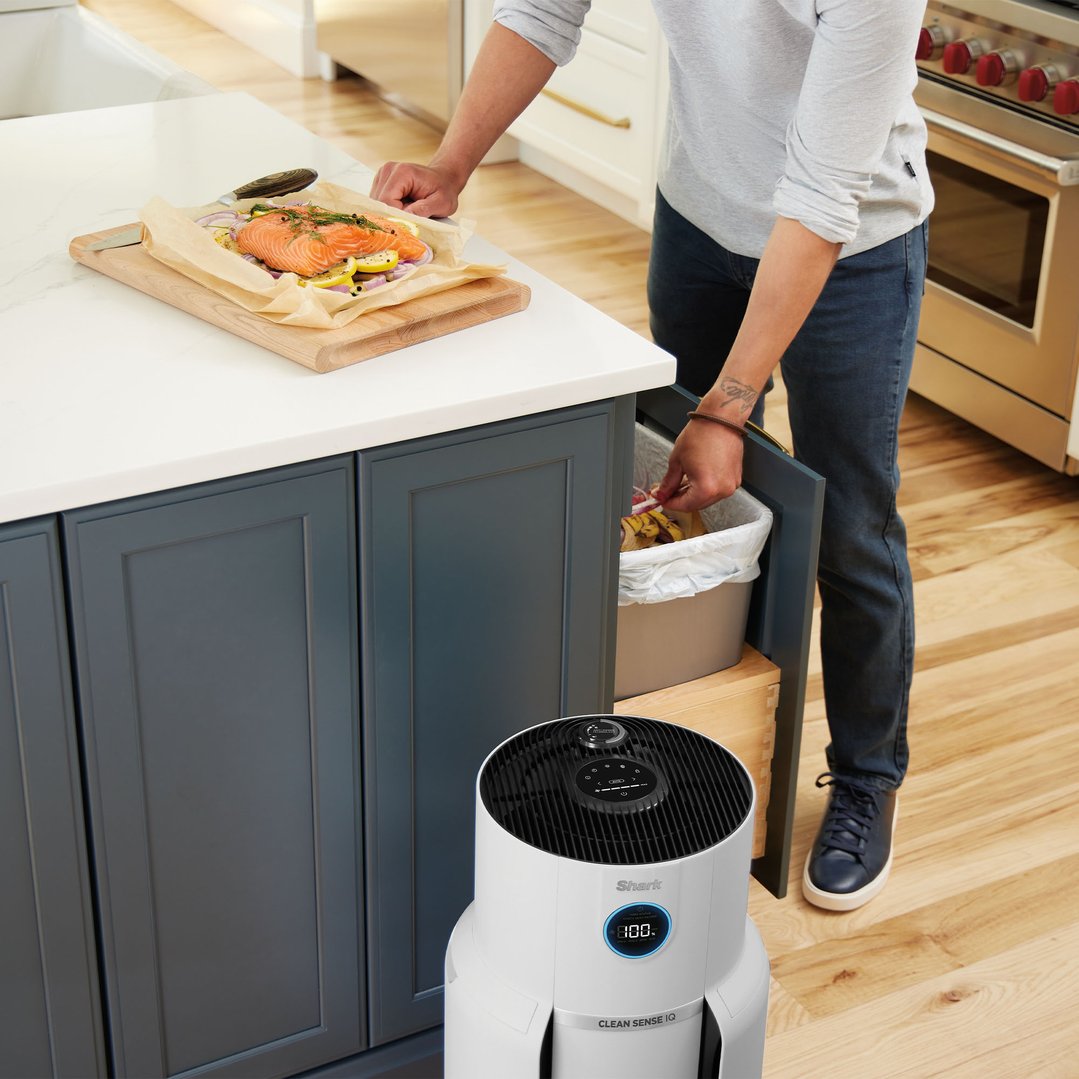 Air purifier on floor in kitchen with person preparing food