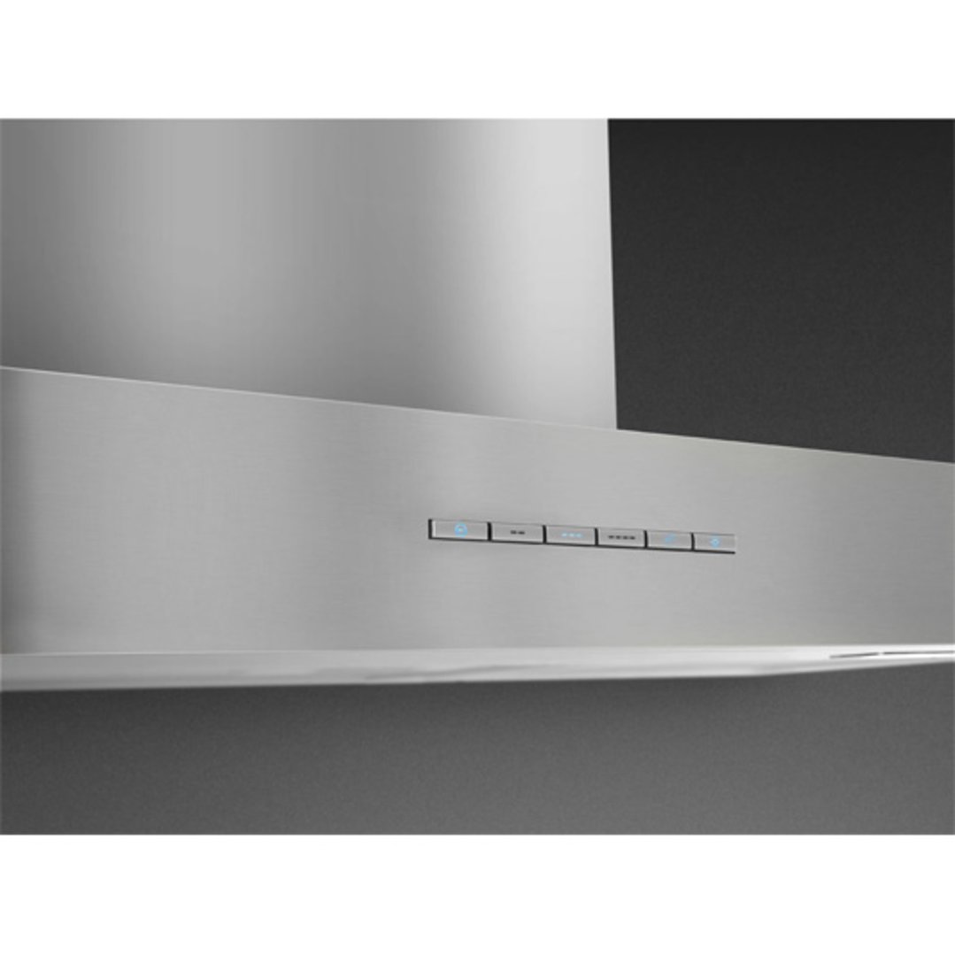 Close up of a stainless steel rangehood with illuminated control buttons