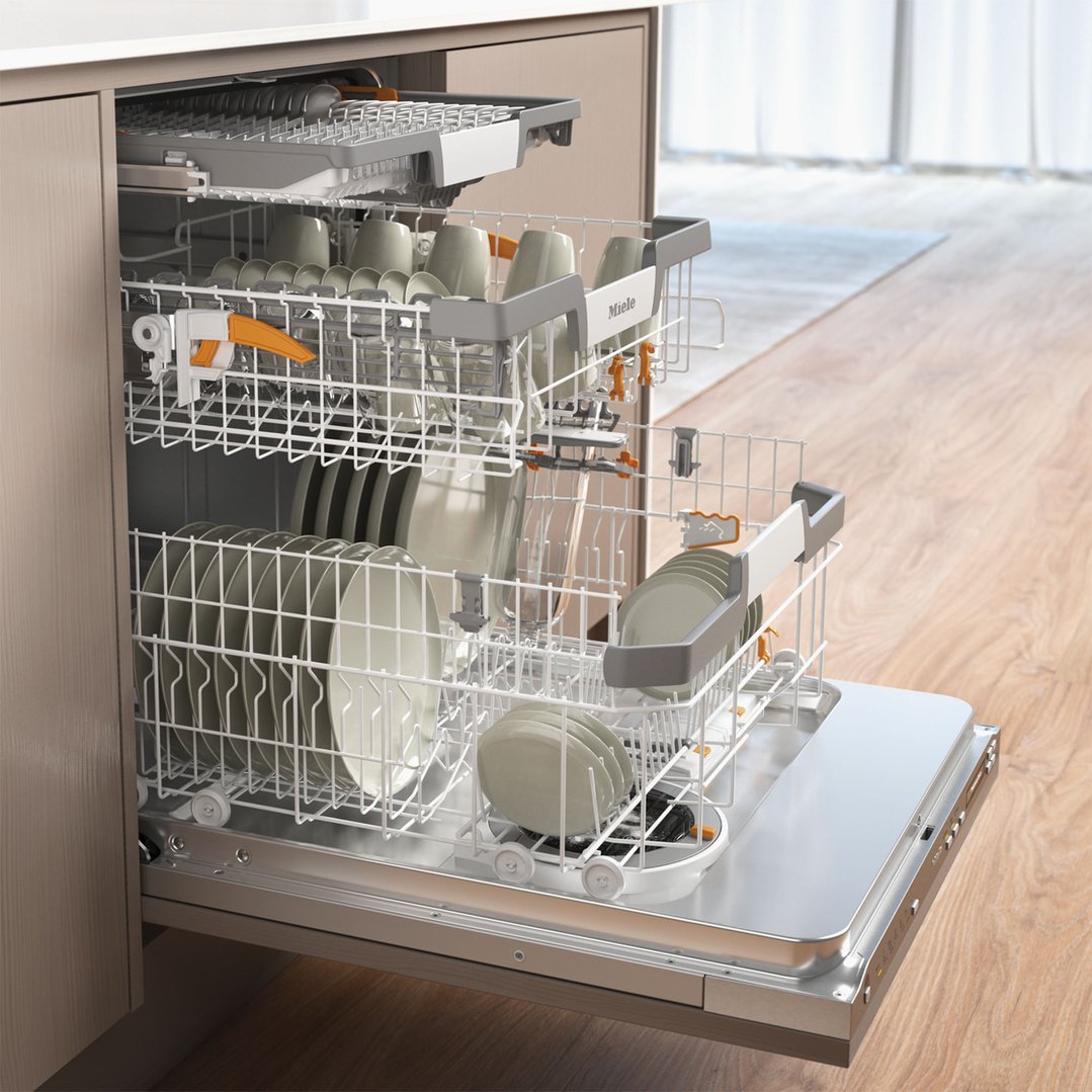 A fully integrated dishwasher with its door open, showing racks filled with dishes