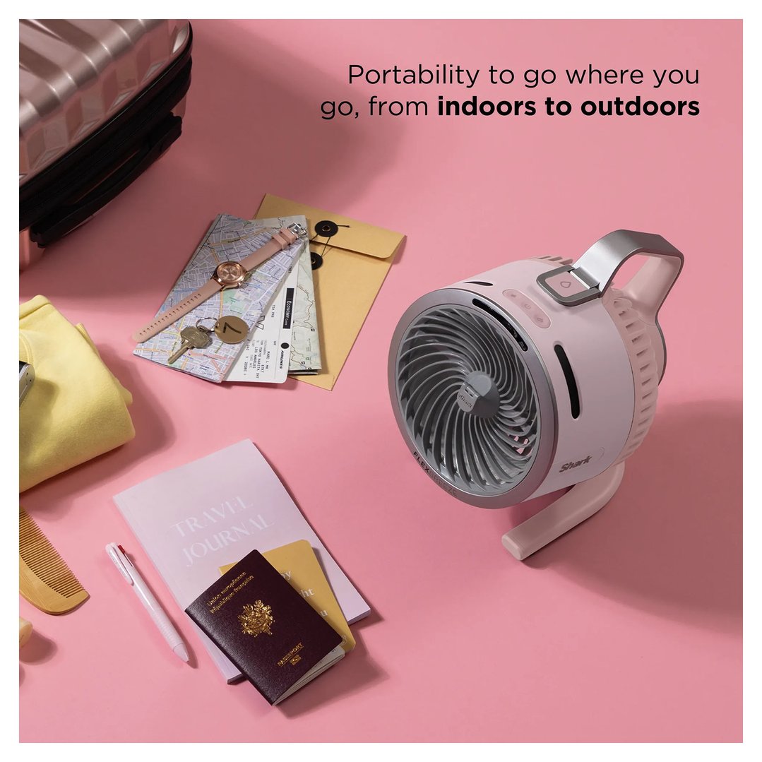 Pink portable fan on a pink surface with travel items and text overlay