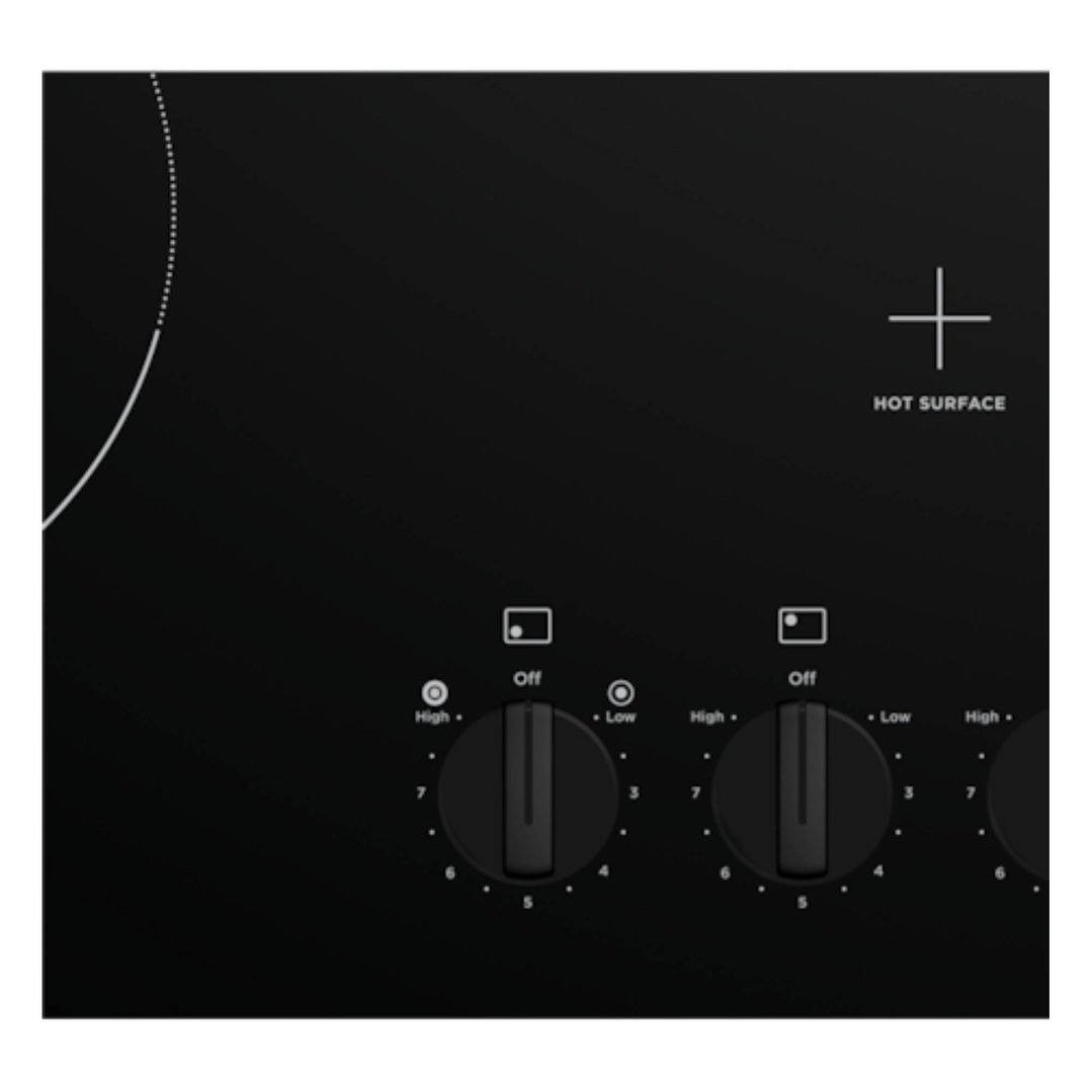 Close up of a black ceramic cooktop with control knobs